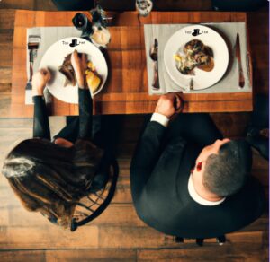 couple enjoying their fancy restaurant meal on plates printed with restaurant logo